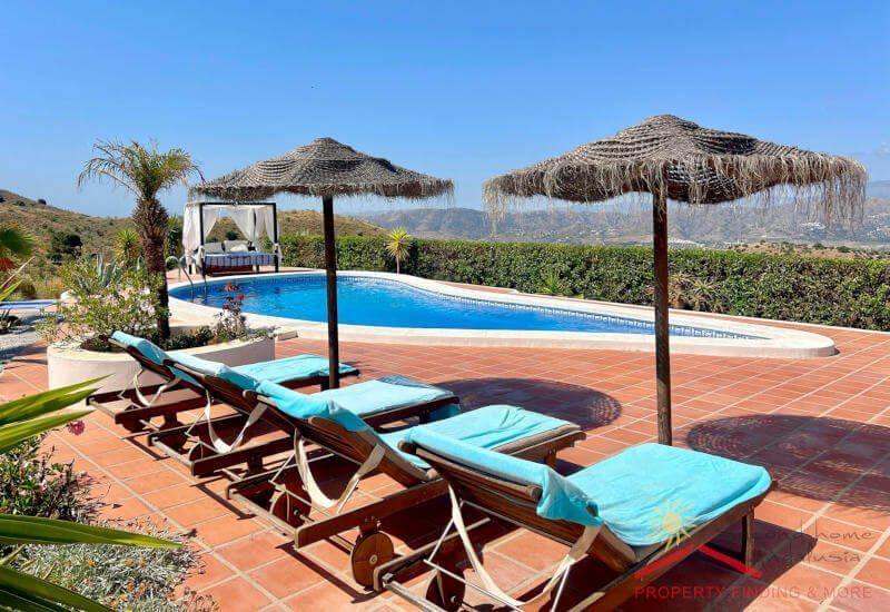 Terrasse am Pool mit Sonnenliege und Sonnenschirme