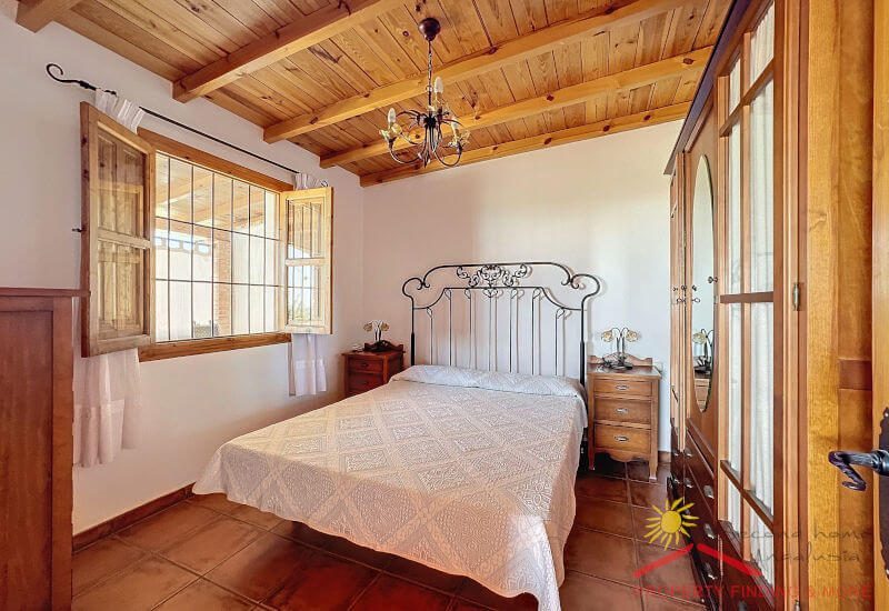 Mooie grote slaapkamer met kingsize bed, houten plafond en raam
