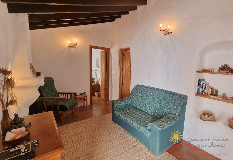 Gemütliches Wohnzimmer mit Sofa und typischer Decke mit Originalbalken