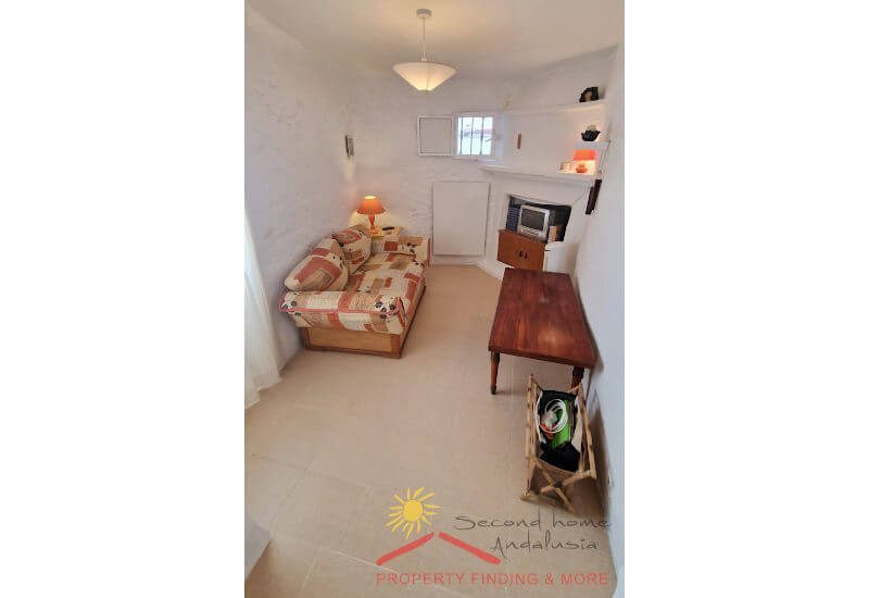 Knusse tv-kamer met bank en een klein raam