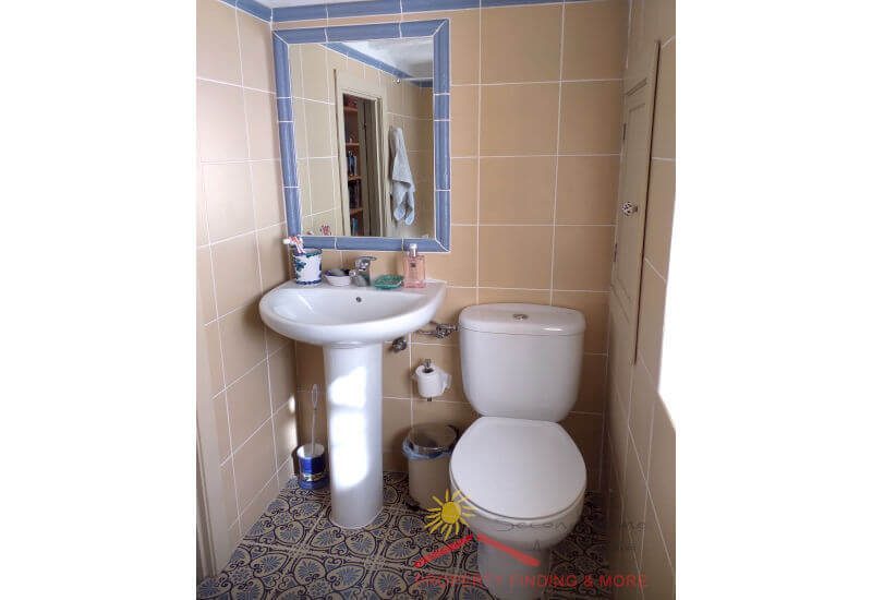Eenvoudige badkamer met wastafel, toilet en douche