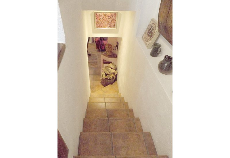 Vanuit de entreehal leidt een trap naar beneden naar de studio.