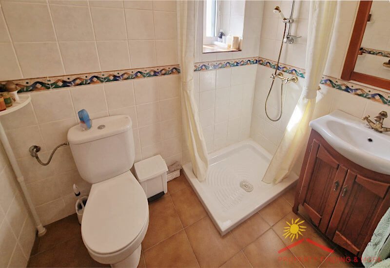 Badezimmer mit einem kleinen Fenster, einer Toilette, einer Dusche und einem normalen Waschbecken