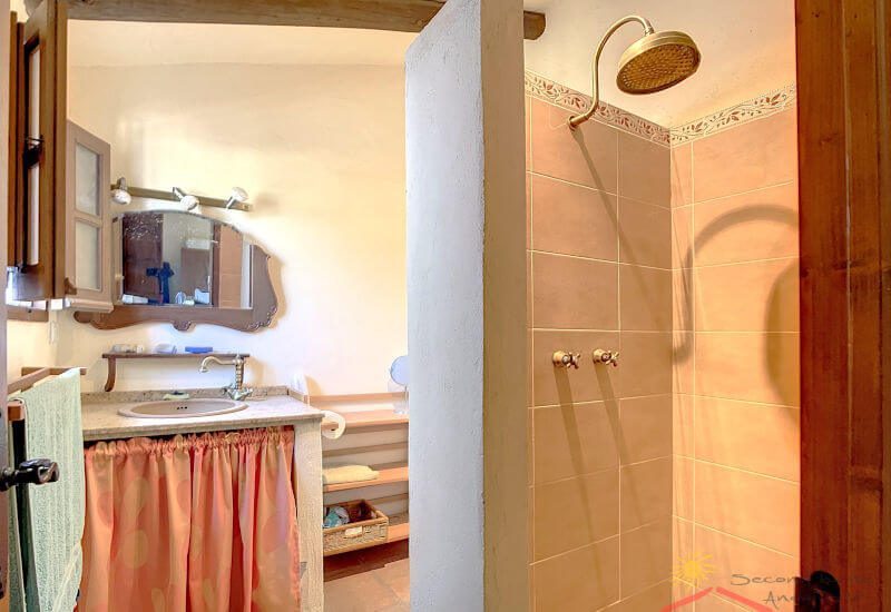 De badkamer maakt deel uit van de hoofdslaapkamer en heeft een douche, toilet en wastafel.