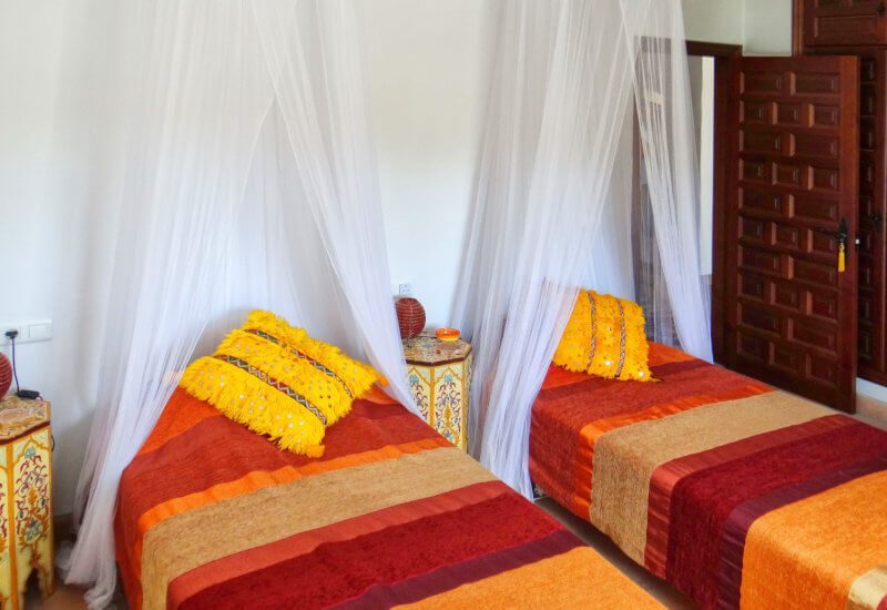 The yellow bedroom for guests has two single beds. 