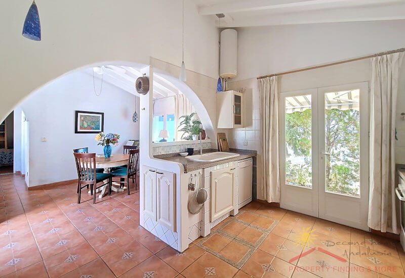 Seating area next to the kitchen and large glass doors leading to the garden