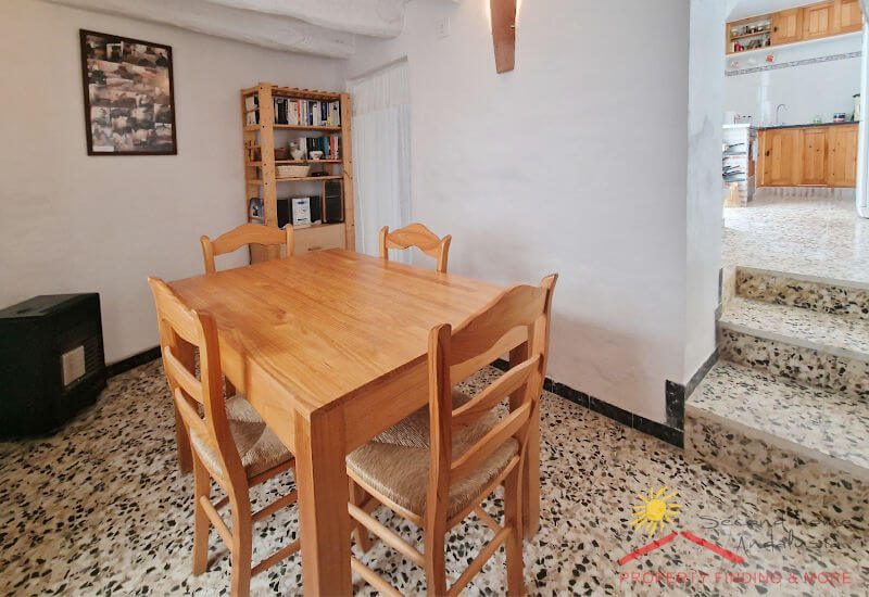 Dining room with wooden table for four persons near the kitchen