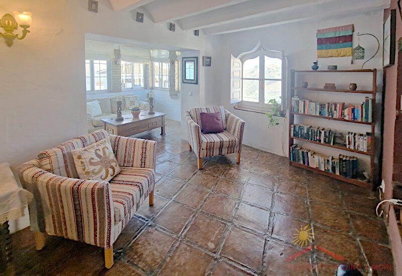 The TV room has original ceiling beams and traditional floor tiles