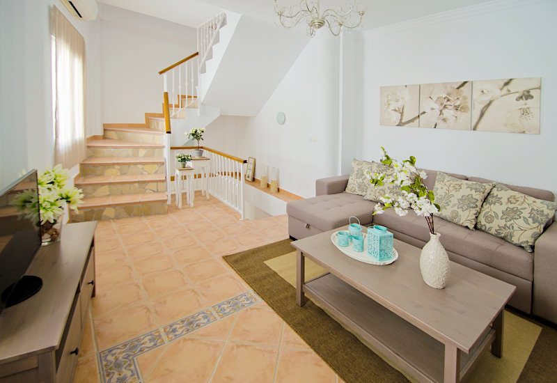 Bright friendly saloon with room for sofa and table. An open staircase makes the room larger
