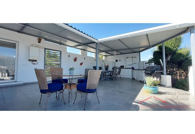 Beside the outdooor kitchen is the outdoor dining partly covered