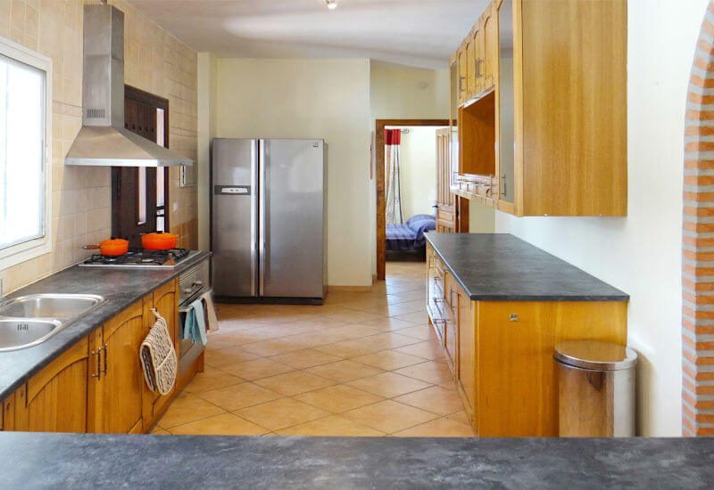 Kitchen with large refrigerator and door to the terrace
