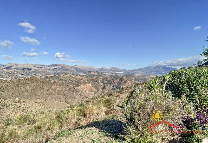 Ver uitzicht over het heuvelachtige landschap van de provincie Málaga met de berg Maroma