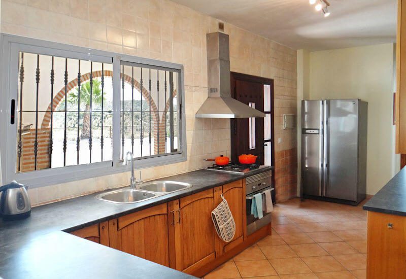 Fully equipped kitchen with large windows to the terrace