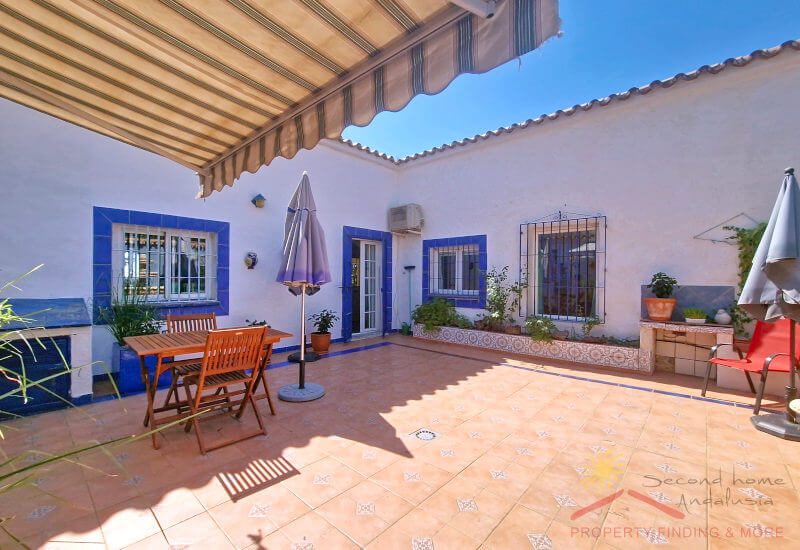 Large courtyard with seating areas and an awning for shade