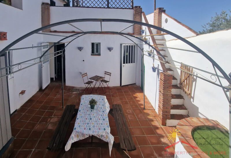 Wide Inner courtyard with sitting area and flowers protected from the wind