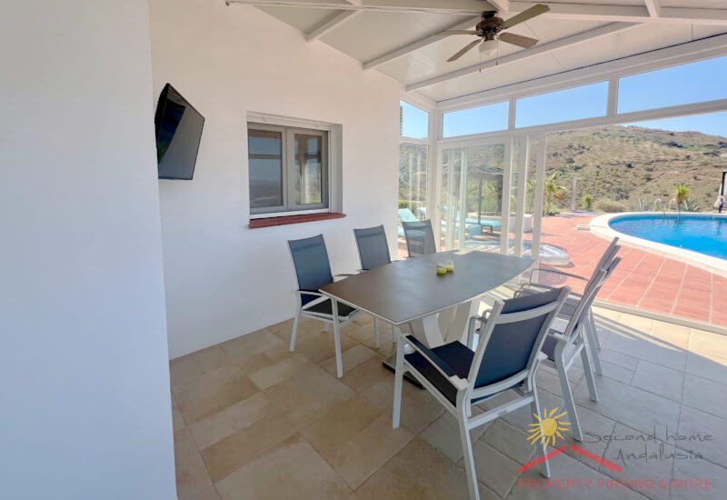 Winter room with large dining table and view of the pool terrace