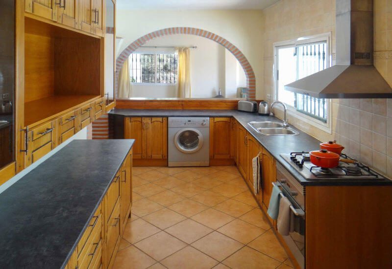 Foto der voll ausgestatteten Küche mit viel Arbeitsfläche.
