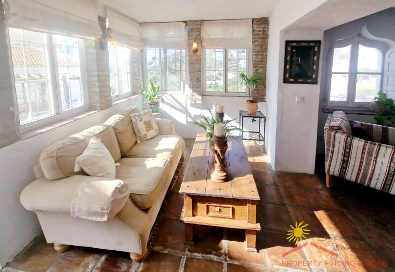 Casa Afifa's sun room with lots of windows and a beautiful sofa