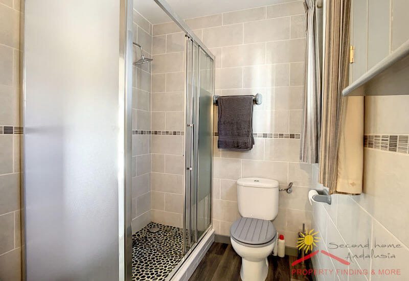 A nice en-suite bathroom contains a large shower, a toilette and basin 