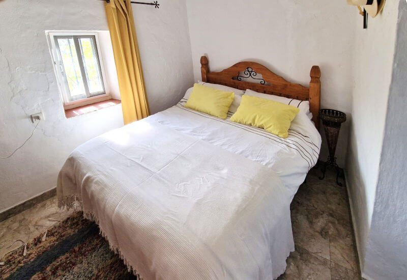 De logeerkamer heeft een Frans bed en een klein raam