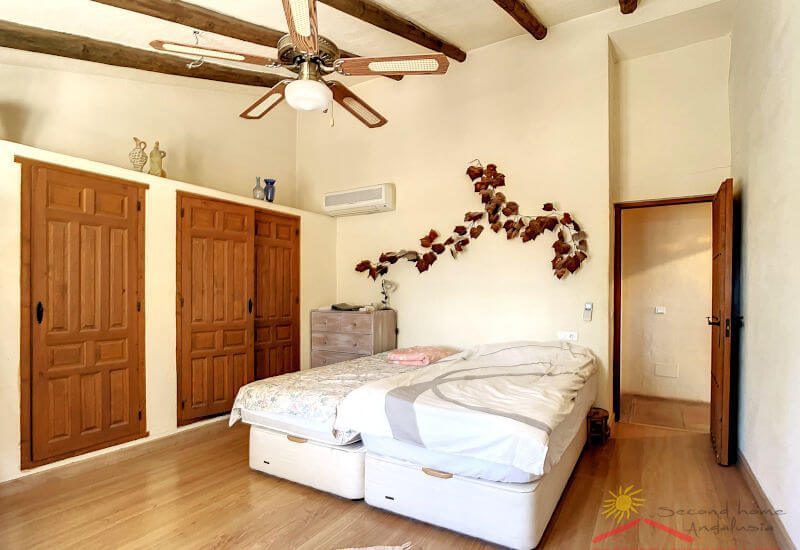 Master bedroom with large wardrobe, double bed and ceiling fan