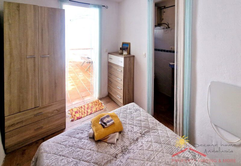 Kleines Schlafzimmer mit Kleiderschrank und Tür zum Innenhof