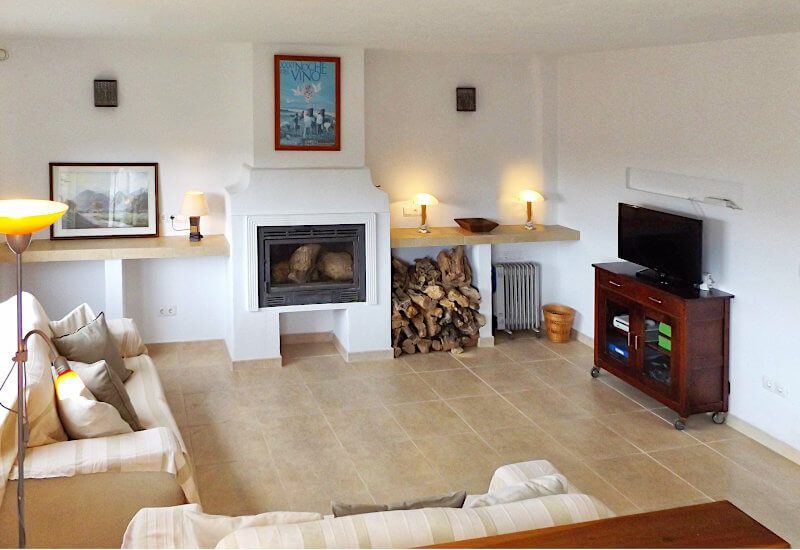 Lounge with sofas and big windows is kept warm by a lockburner