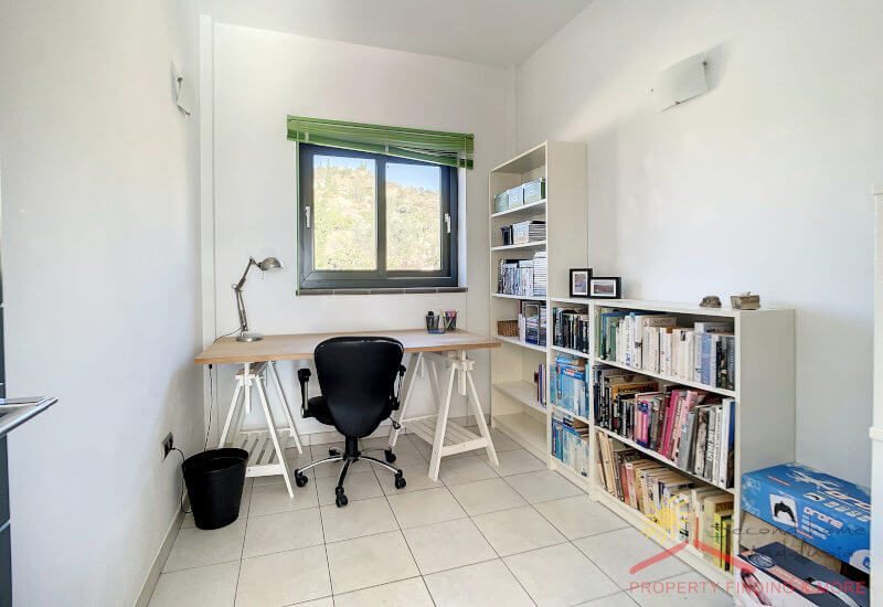 Büro mit einem großen Fenster, Platz für einen Schreibtisch und einige Regale