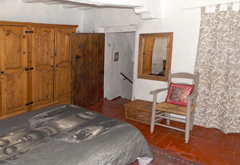 Master bedroom with 4 door wardrobe, old fashioned small wooden door towards staircase
