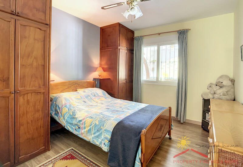 Das Gästeschlafzimmer hat ein Doppelbett, einen Kleiderschrank aus Holz und ein Sideboard