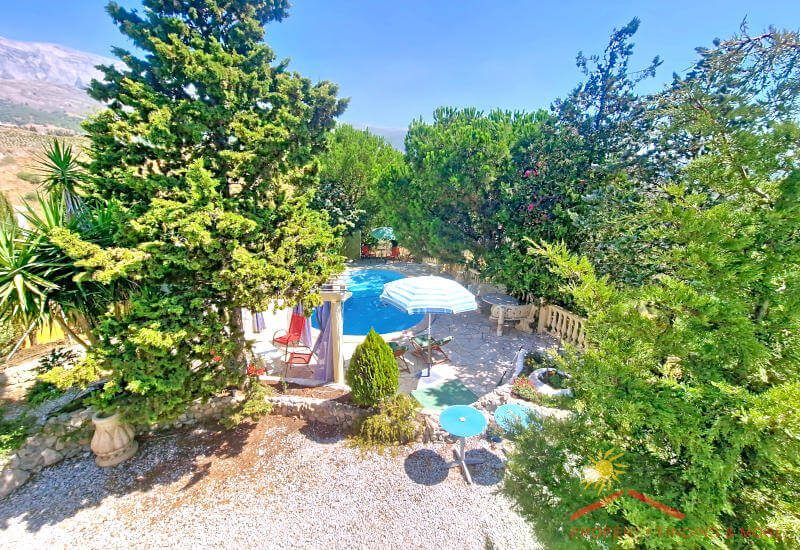 Vom Balkon sieht man aus den Garten mit Terrasse und Pool und im Hintergrund die Maroma