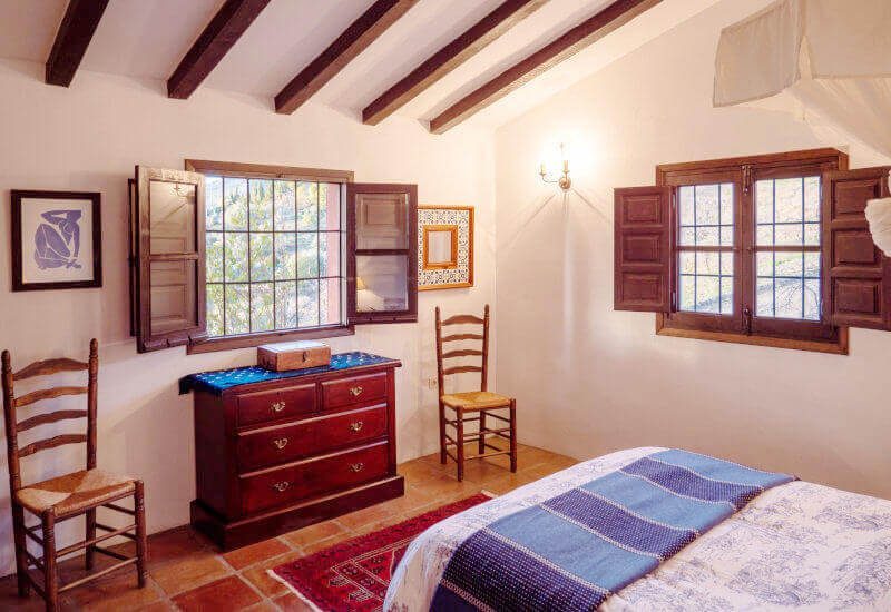 Bedroom with king size bed, and a lot of space for chairs and sideboard and two windows