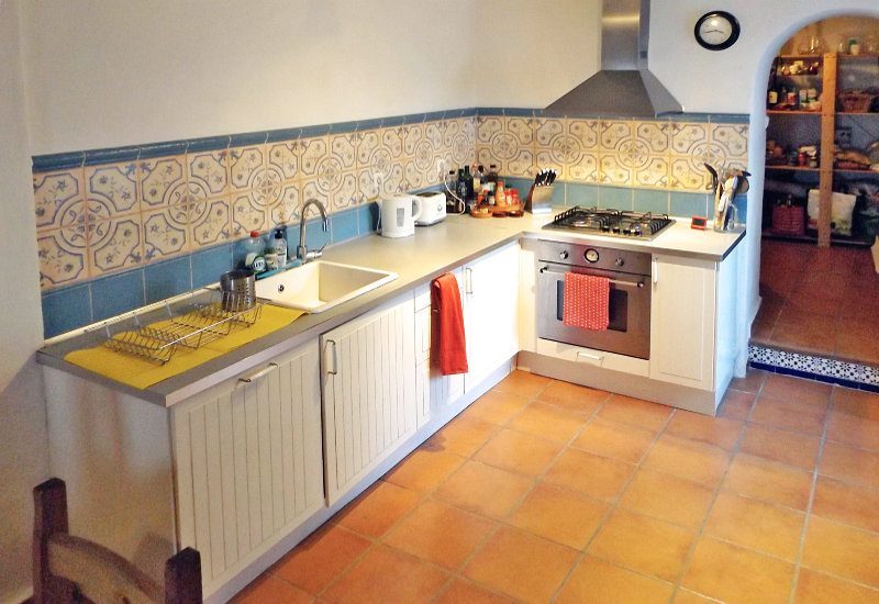 Kitchen with modern gas stove, spacious sink and access to the storeroom