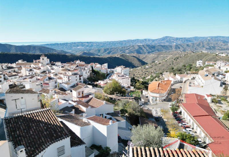 View from roof terrace over the houses of Canillas de Aceituno and the hills of the Axarquía and the Mediterranean Sea in the back
