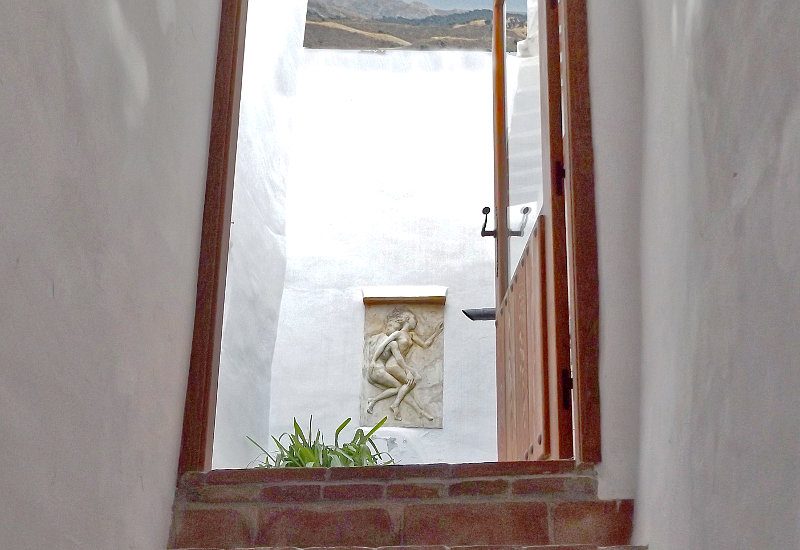 Een trap van beneden leidt naar de ondiepe binnenplaats. De mounains zijn van hieruit zichtbaar.