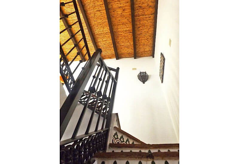 Die Treppe zum Obergeschoss zeigt die Decke mit traditioneller Holzdecke 