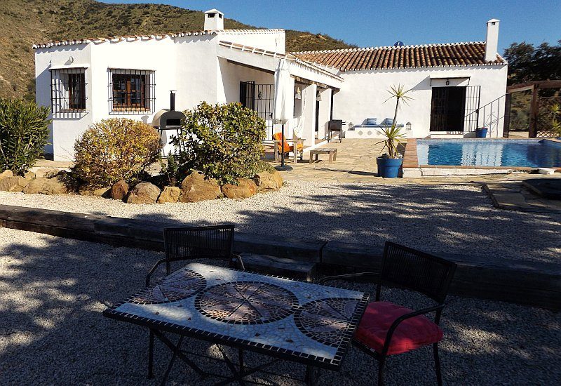 Photo of the Finca from the garden with the pool area and the house itself.