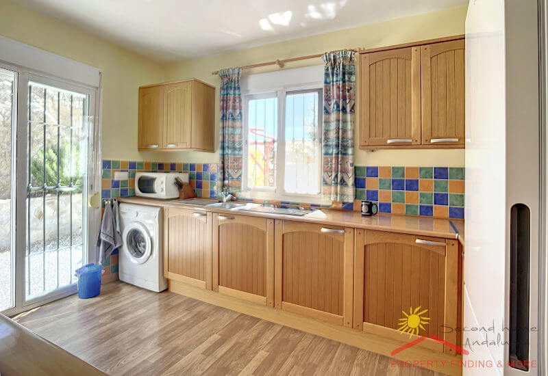 Fully equipped kitchen with large window and double door to the garden