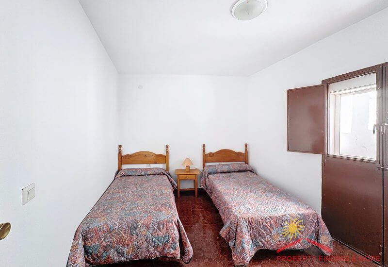 Een slaapkamer met twee eenpersoonsbedden en een grote glazen deur