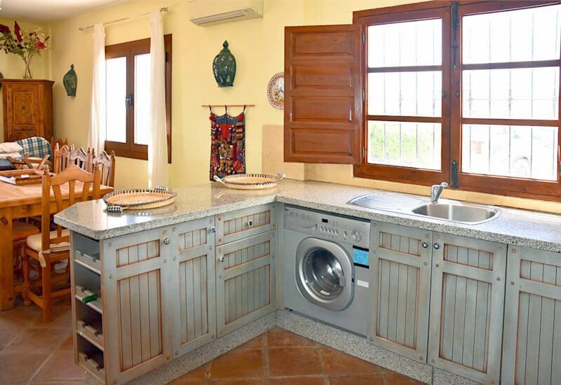 Keuken met wasmachine en open naar de eethoek