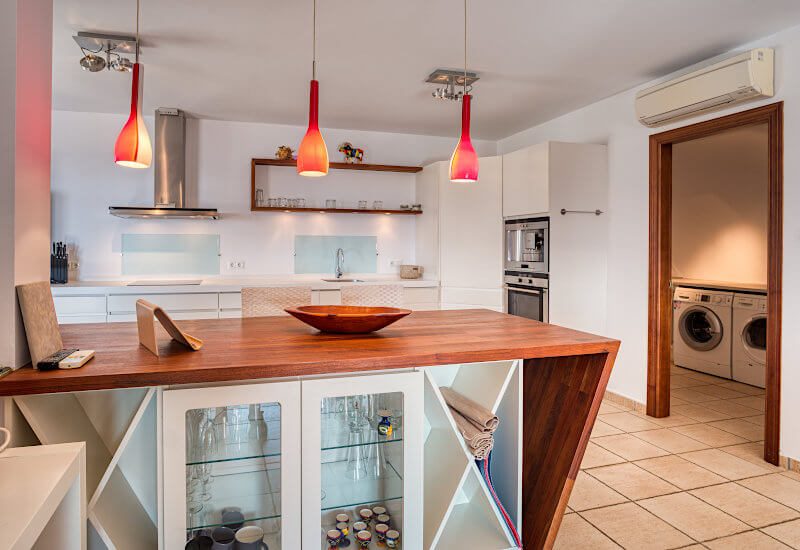 Een houten bar met ingebouwde vitrine verdeelt de keuken.