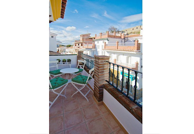 Balkon met zithoek en uitzicht op calle Villa de Castillo