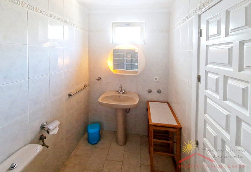 The 2nd bedroom has a small ensuite bathroom with a little window, a basin on one side and a toilette in the middle.
