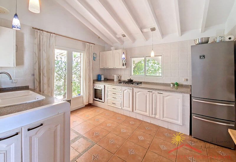 Fully equipped kitchen with large glass doors and window to the terrace
