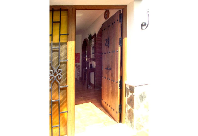 De houten deur van de entree is rustiek en breed
