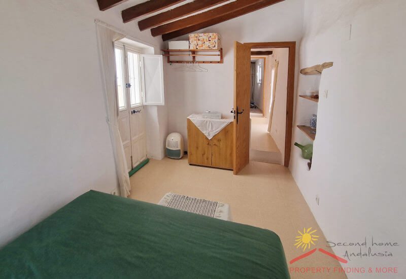 Kleine slaapkamer 2 heeft een rustieke inbouwkast en een openslaande deur naar het terras 