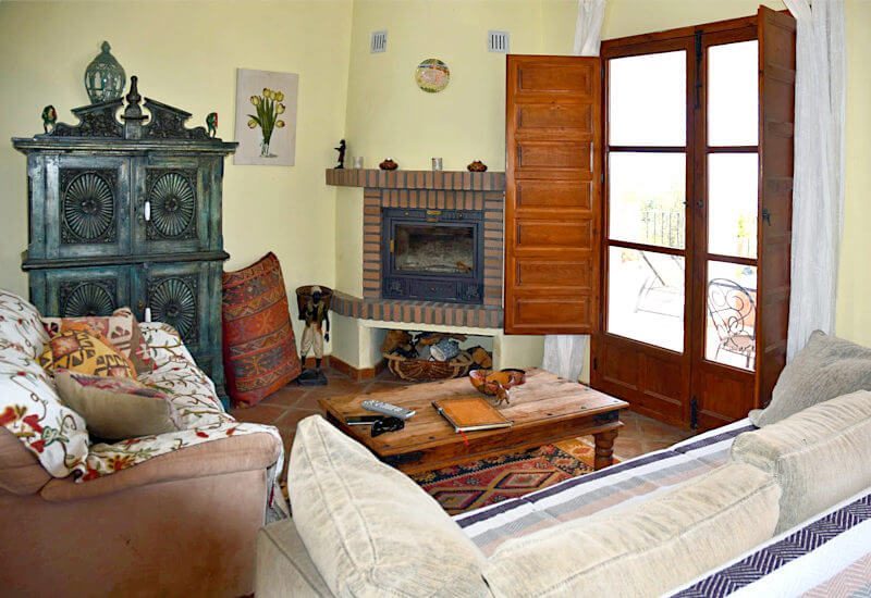 Wohnzimmer mit Kamin, Sitzecke und großer Terrassentür