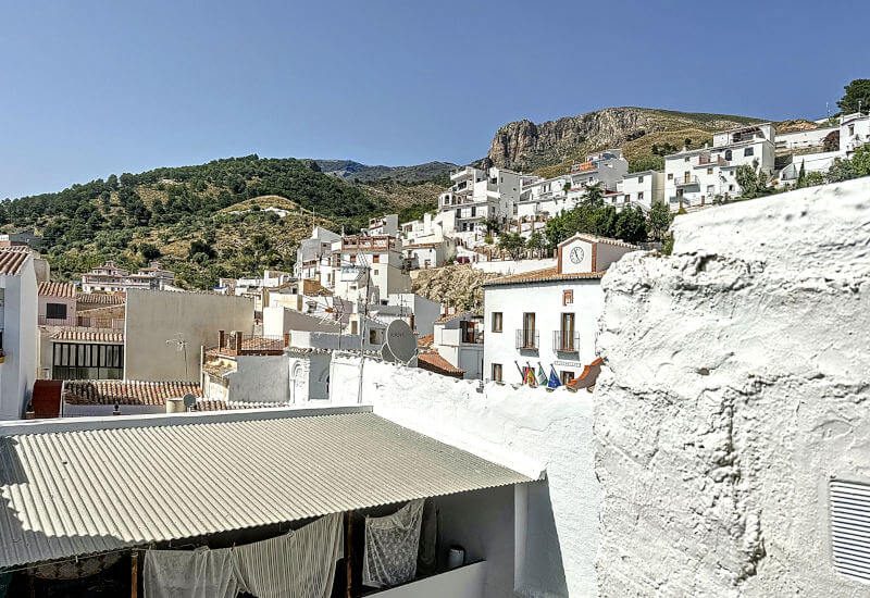 Der Blick von der Dachterrasse geht über das Oberdorf von Canillas de Aceituno und die Berge dahinter
