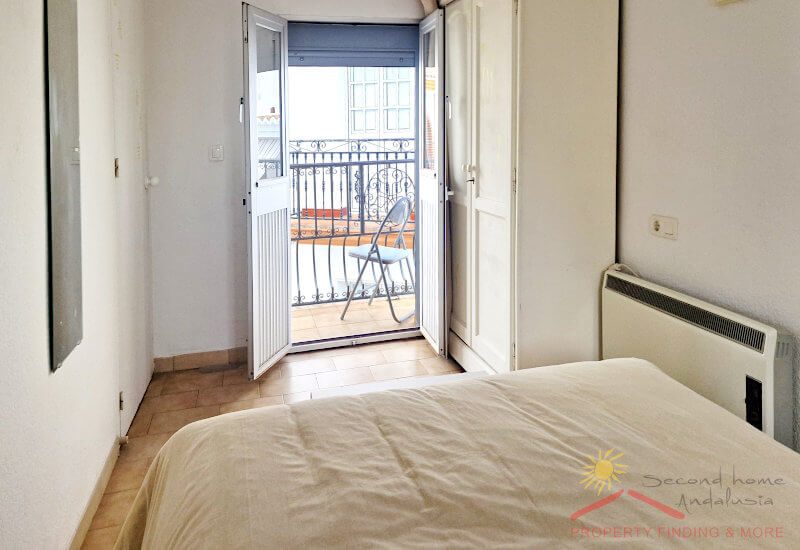 Slaapkamer 2 met meegebracht bed en een glazen deur naar het balkon