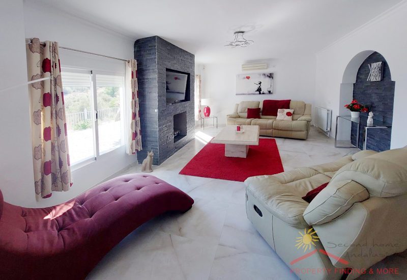 Lounge with two big windows, a chimney and a wide sitting area